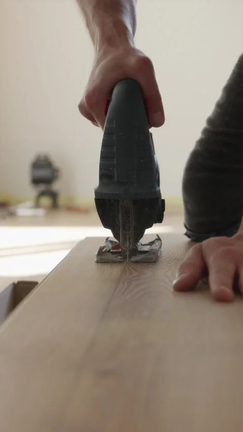 Slow motion view of electric jigsaw cutting laminate floor board Vídeo Stock 346396773