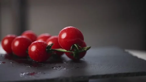 Slow motion view of fresh cherry tomatoes falling down. Presentation of Stock Footage 231286322