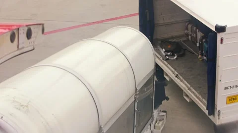 Slow motion view of ground crew loading luggage into aircraft at airport ramp Stock Footage 322640325