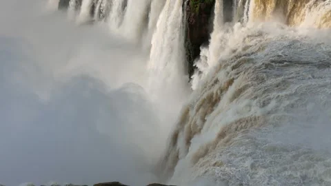 Slow motion view of Iguazu Falls where thunderous water crashes below cliffs Stock Footage 311240634