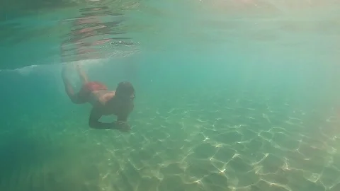 Slow Motion View: Man Jumps Into The Sea With Sunrays Illuminating Him Stock Footage 121310734