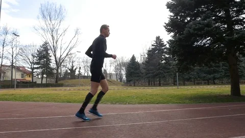 Slow motion view of man starting to jog on the course track Stock Footage 74597479