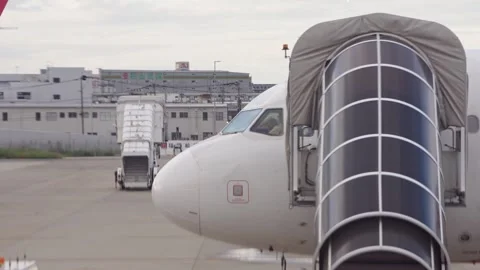 Slow motion view of parked aircraft with jet bridge on airport apron in Japan Stock Footage 321420151