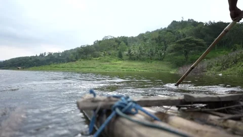 Slow motion view of people rowing a bamboo raft Stock Footage 262293224