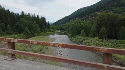 Slow Motion View of River and Train Trestle from Moving Car in Montana Stock Footage 320356191