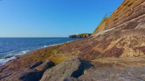 Slow motion view of rocky shore and blue coastal waters Stock Footage 340451928