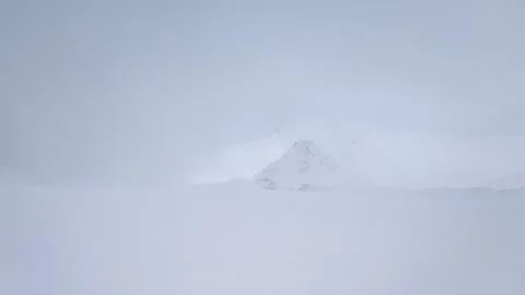 Slow motion. View of the snow-capped mountain peak in a blizzard with a strong Stock Footage 166092619