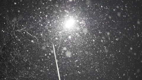 Slow Motion. A view of snowflakes falling under the street lantern lights. Stock Footage 226069274