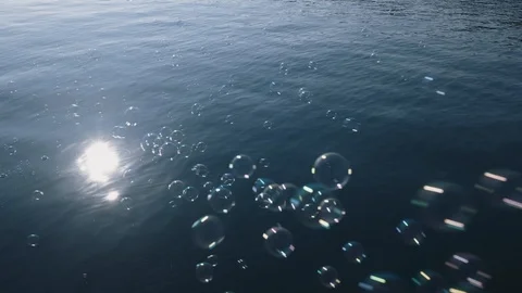 Slow motion view texture blue sea with small waves and flying soap bubbles Stock Footage 106376173