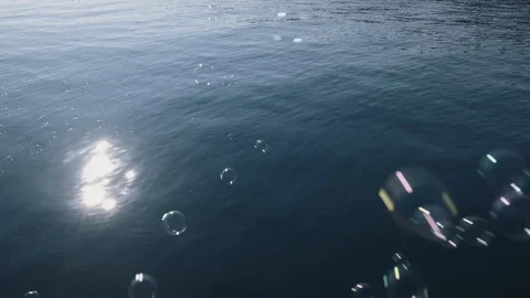 Slow motion view texture blue sea with small waves and flying soap bubbles Stock Footage 106376655