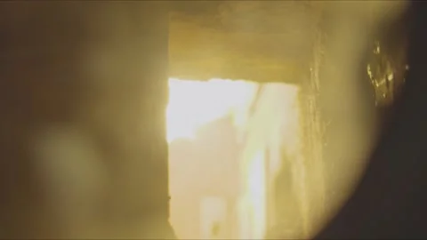 Slow motion view through a boiler inspection port showing a burner flame moving Stock Footage 346603365