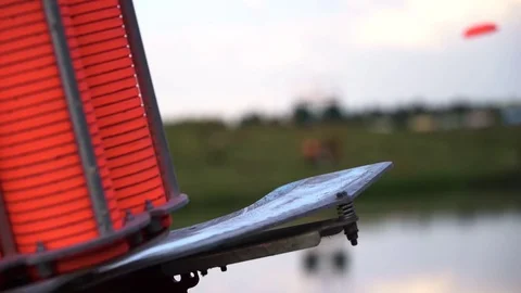 Slow motion view of throwing machine for clay pigeon shooting with orange plates Stock Footage 116505552