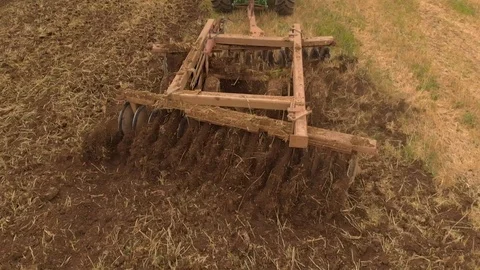 Slow motion view of tractor plowing a field a from drone Video stock 95336064
