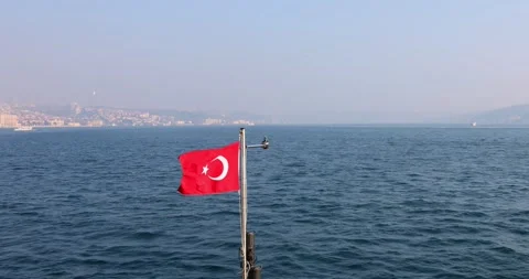 Slow motion view of the Turkish flag on a ship cruising the Istanbul Bosphorus Stock Footage 299819409