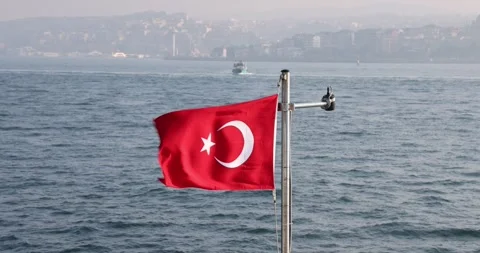 Slow motion view of the Turkish flag on a ship cruising the Istanbul Bosphorus Stock Footage 300169927