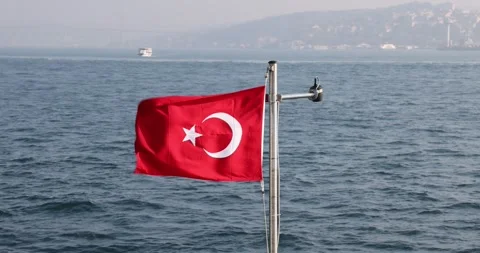 Slow motion view of the Turkish flag on a ship cruising the Istanbul Bosphorus Stock Footage 300172630