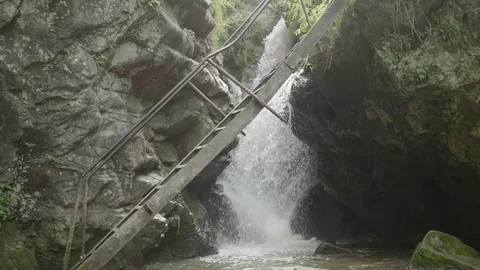 Slow motion view of waterfall through ledder bridge Stock Footage 82903410