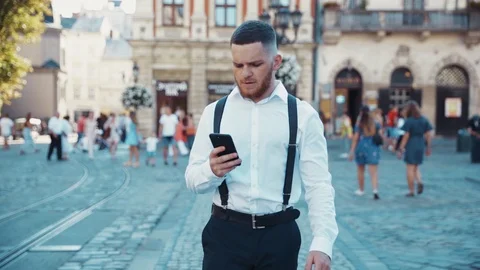 Slow motion view of young handsome businessman in casual outfit walking down the Stock Footage 115666953