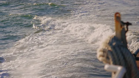 Slow motion wake and surf behind moving boat, view from deck looking back Video stock 242861404