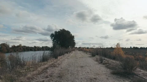 Slow motion walk on levee with pretty clouds Stock Footage 259351893