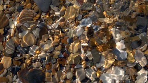 Slow motion of walking dripping on shallow pure water with shingle bottom. Stock Footage 98094752