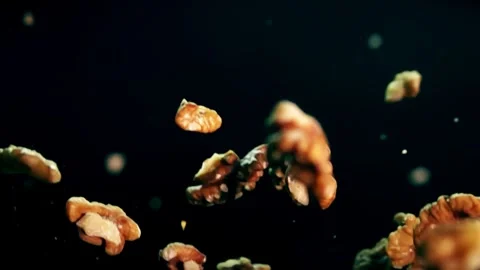 Slow Motion Walnut Pieces Falling Against Dark Background Video stock 272188855