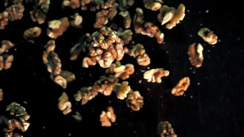 Slow Motion Walnuts Falling Against a Dark Background in a Studio Setting Video stock 272190286