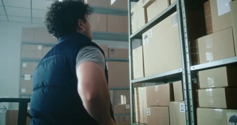 Slow motion of warehouse associate scanning code, loading parcel on pallet truck Stock Footage 307583852