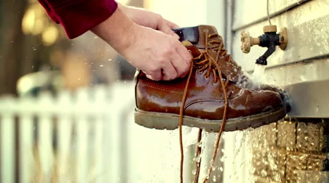 Slow motion washing pair of boots under garden tap HD Stock Footage 48906775