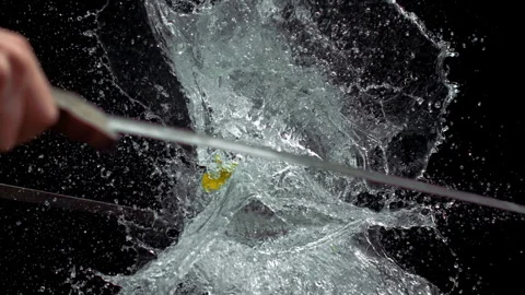 Slow Motion Of Water Balloon Exploding From Dual Sword Slashes Video stock 314302775