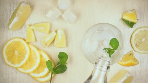 Slow motion water from a bottle is poured into a glass Stock Footage 87754804