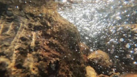 Slow motion water bubbles at the bottom of a clear mountain river Stock Footage 319809510