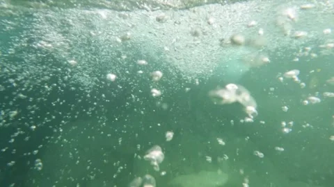 Slow motion of water bubbles under the surface of a clear river Stock Footage 321861189