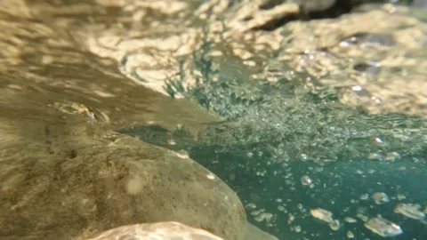 Slow motion of water bubbles under the surface of a clear river Stock Footage 321861196