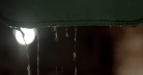 Slow motion water dripping off a window awning during a rainstorm at night 스톡 동영상 126883447