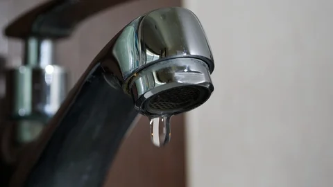Slow motion water drop leaking in close faucet Stock Footage 98242305