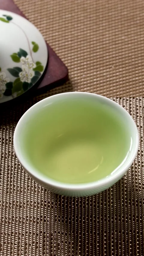 Slow Motion Water Droplet Falling into Green Tea Cup Stock Footage 340006168
