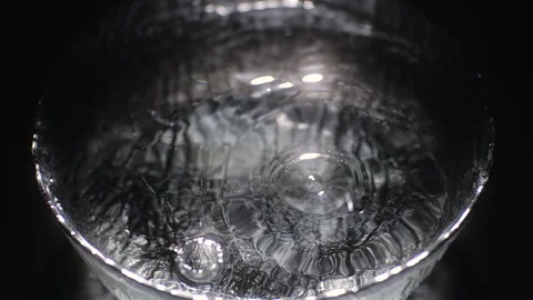 Slow motion of water drops dripping into a plate filled with water 库存影片 149940547