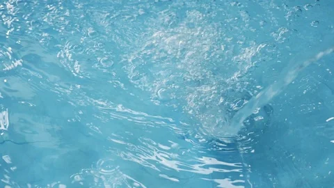 Slow-motion water falling from rubber tube splash pouring in blue baby pool Stock Footage 90376291