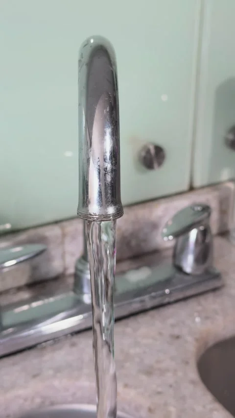Slow motion water flow from chrome faucet in kitchen sink Stock Footage 311339253
