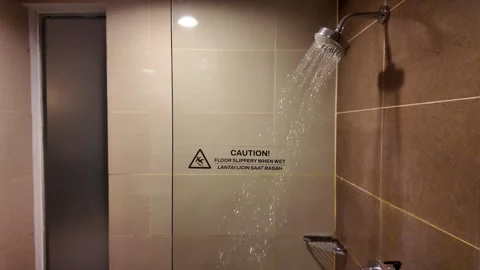 Slow Motion Water Flowing From Shower Head With Caution Slippery Floor Sign Stock Footage 344087627