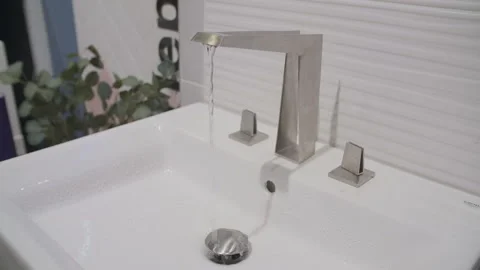 Slow motion, water flows from a chrome faucet Stock Footage 133130877