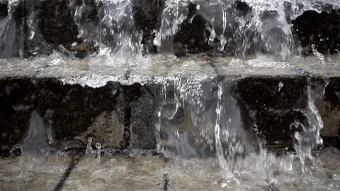 Slow motion water flows flowing down a stone staircase. Stock Footage 118737813