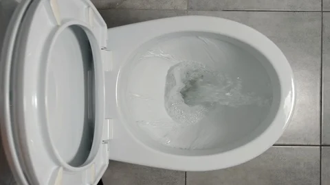 SLOW MOTION: Water flows in a white toilet Видео 90239996