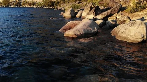Slow Motion Water Lapping Shore of Lake Tahoe and Boulders - Aerial Drone. Stock Footage 114213484