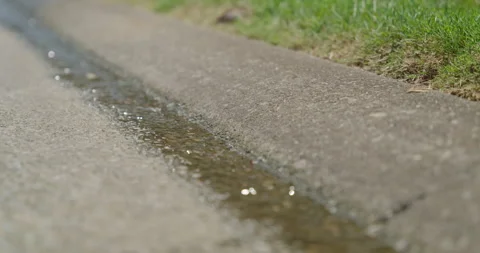 Slow Motion Water Running Down Street Gutter 2 Stock Footage 243854944