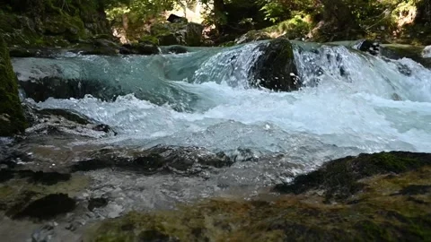 Slow motion of water running over rocks of a mountain stream Video stock 260868664