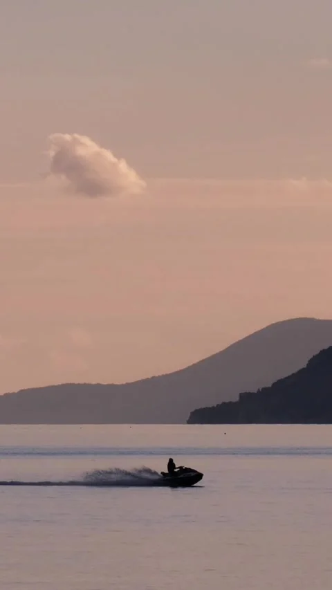 Slow motion of a water scooter passing by the bay Stock Footage 270534853