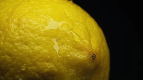 Slow motion water splash on fresh lemon macro, high speed droplets, vibrant.. Stock Footage 333485994
