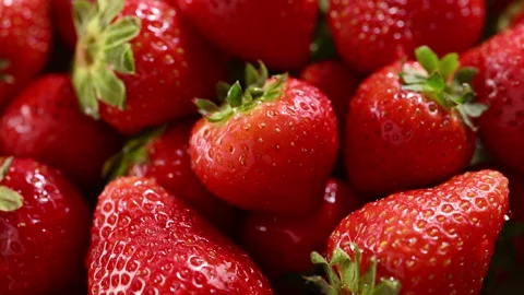 Slow-motion water splashes juicy strawberries on spinning turntable Stock Footage 314332895